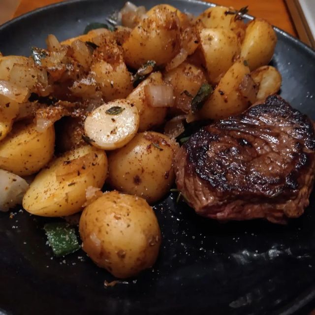 Tonight's dinner was steak and potatoes. 

The potatoes are small yellow ones #frommygarden that I cut in half. I start off boiling/poaching them because otherwise I always get the outside too cooked before the inside is cooked, and this both slows me down to give them more time and provides more even heat.

Once the water cooks off (or I get impatient and pour the water out), I add fat. This time I added a chunk (1tsp?) of bacon grease from my freezer. Then I let the potatoes cook and color for about five minutes before adding diced onions and peppers (a poblano #frommygarden ). Stir it enough that nothing burns and sticks to the skillet. Once the onion is soft, I can add minced garlic. I also added dried thyme (#frommygarden) and paprika, black pepper, salt, and #penzeysspices 's Turkish Seasoning. 

The steak was cooked in a hot cast iron skillet starting about when the garlic went into the potatoes. 

It's actually half a steak. I cut off some strips with ambitions toward making a stir fry later in the week